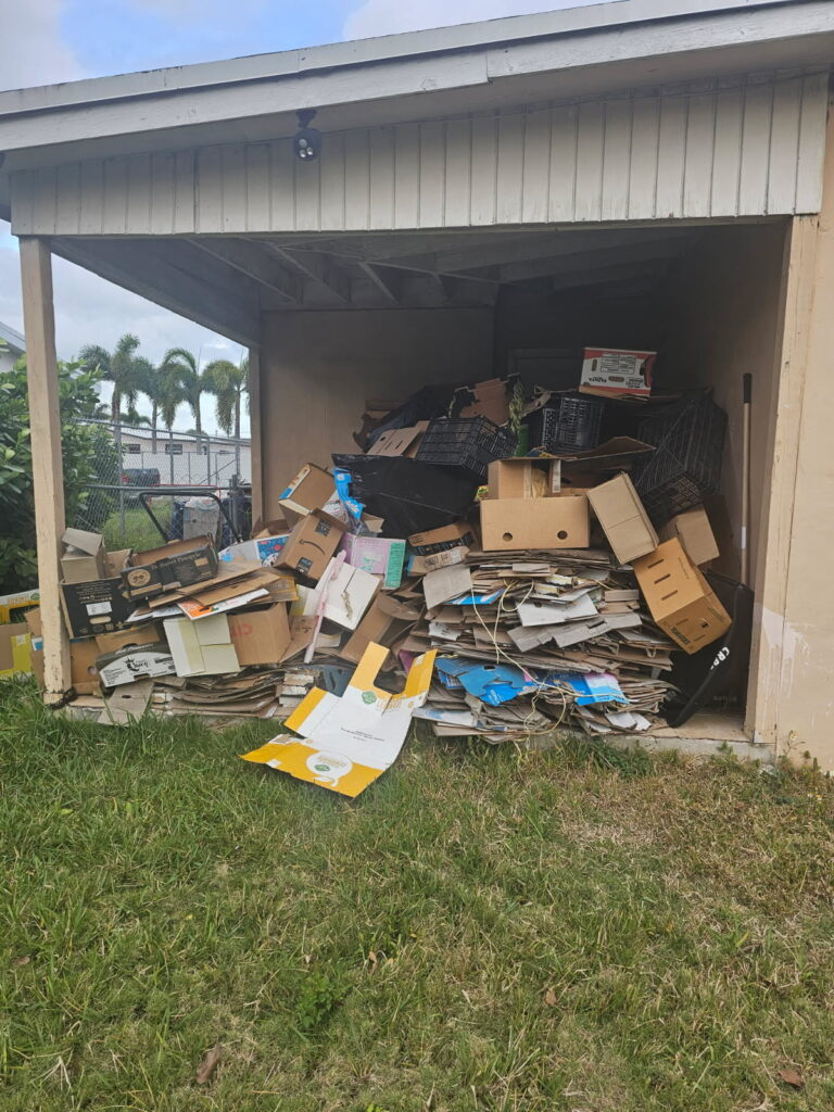 A cluttered storage area filled with stacked cardboard boxes and other materials.